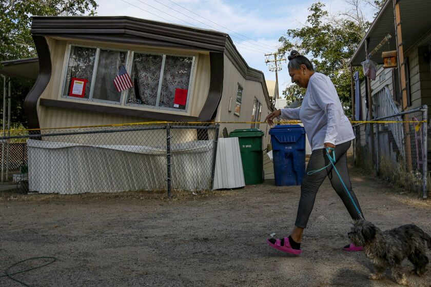 RIDGECREST, CA - JULY 05, 2019  Carmen Rivera, 65, on morning walk with her dog Ash passes by a mobile home dislodged in Torusdale Estates mobile home park by yesterdays 6.4 earthquake in Ridgecrest. (Irfan Khan / Los Angeles Times)