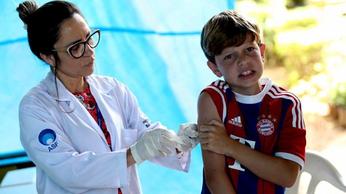 A Brazilian boy in Sao Paulo winces as he gets the yellow fever vaccine.
