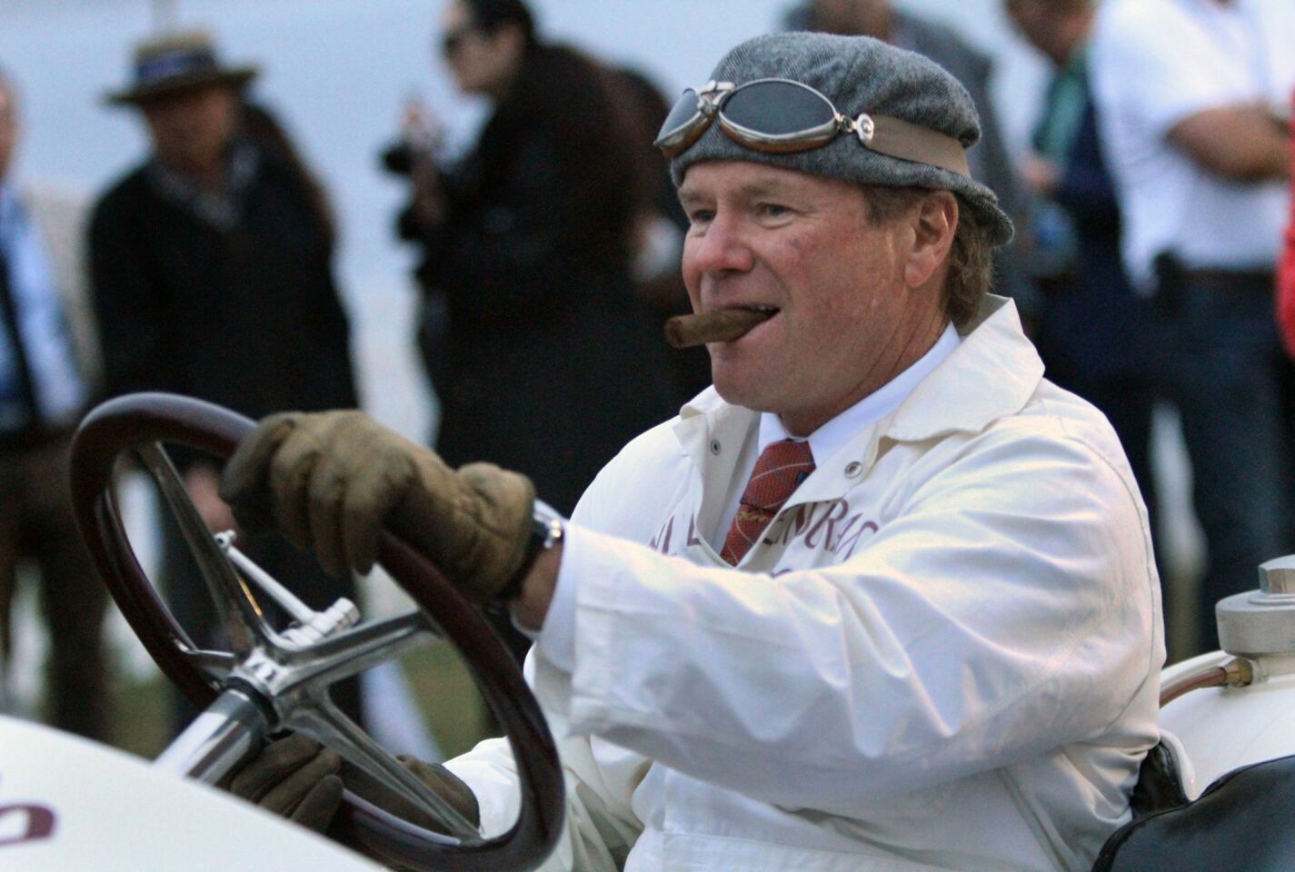 Chewing on his cigar, Rick Rawlins drives a 1908 Prince Henry Benz, owned by Ann Bothwell but originally owned by race car driver Barney Oldfield, as nearly 200 collector cars greet the dawn as they roll onto the 18th fairway at Pebble Beach to begin the Pebble Beach Concours d'Elegance.