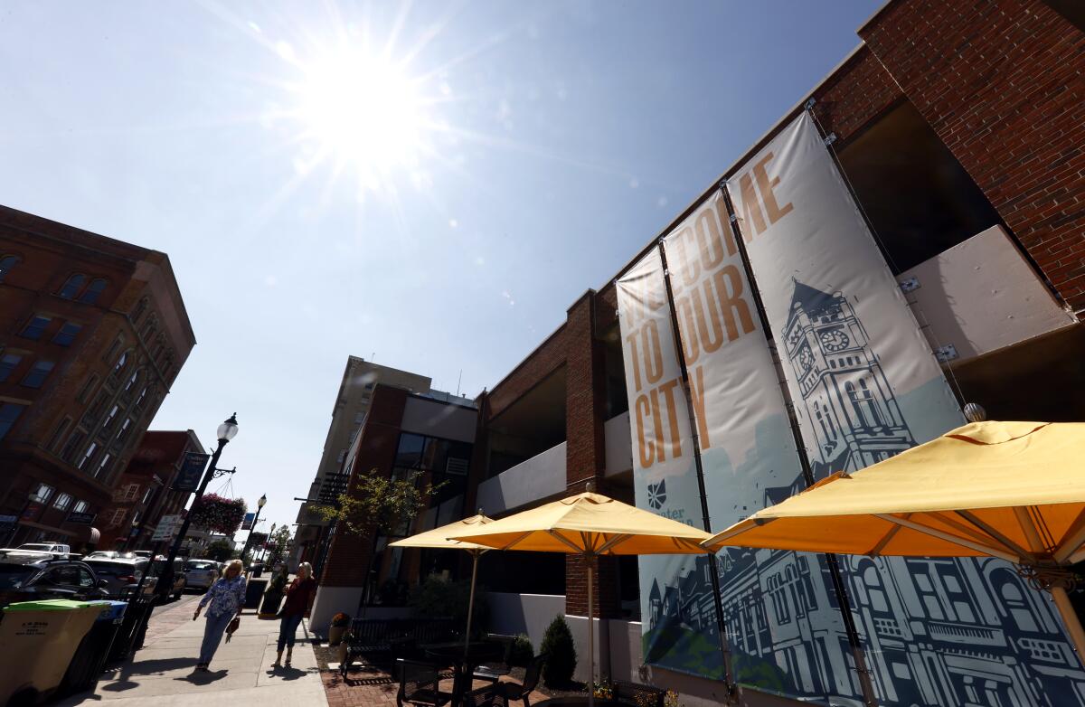 Pedestrians walk through a commercial district on a sunny day 