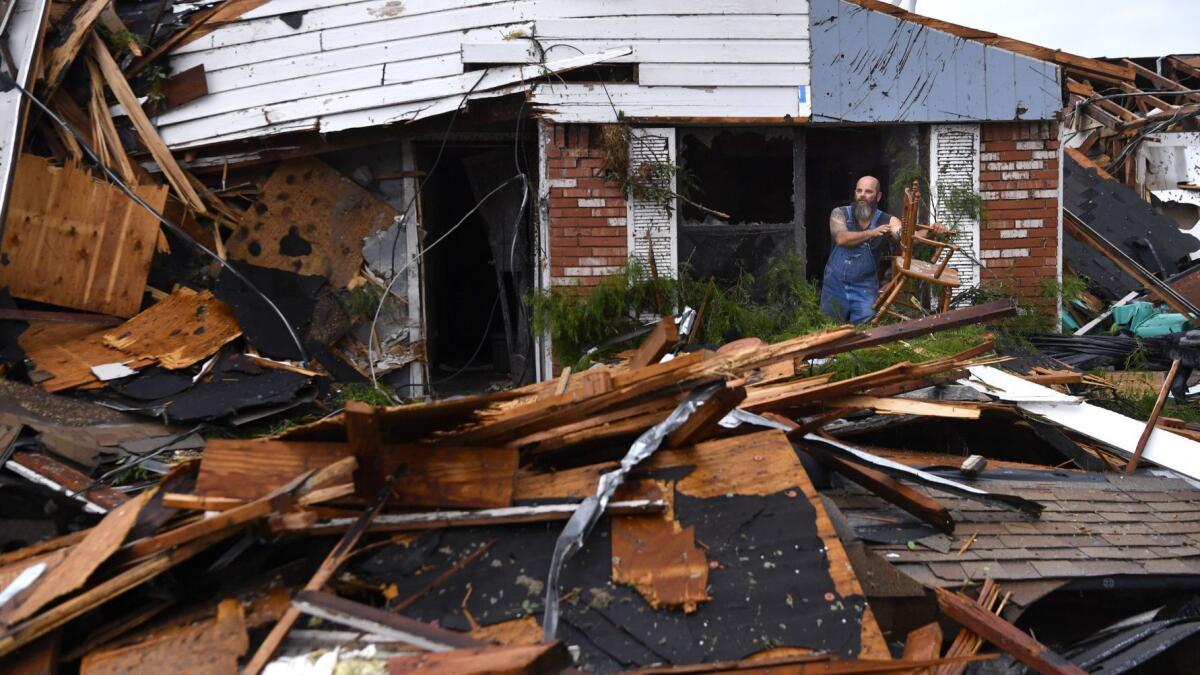 Wesley Mantooth lifts a chair through a window of his father's home in Abilene, Texas, on May 18. Residents said a tornado struck in the early-morning hours.