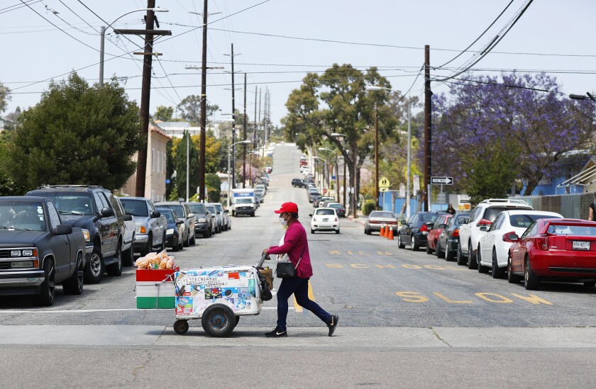 A pushcart vendor walks through a Logan Heights neighborhood.