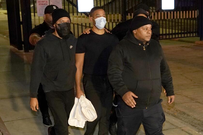A group of men wearing black leave a jail