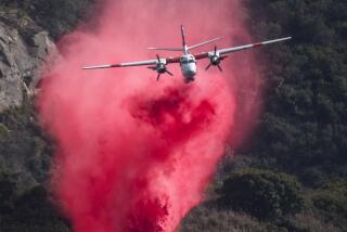 A Cal Fire S2 air tanker makes a fire retardant drop near Top of the World Drive in Laguna Beach. 