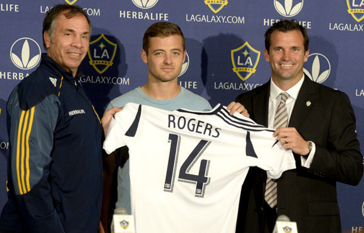 New Galaxy midfielder Robbie Rogers is flanked by Coach Bruce Arena, left, and team President Chris Klein during an introductory news conference on Saturday.