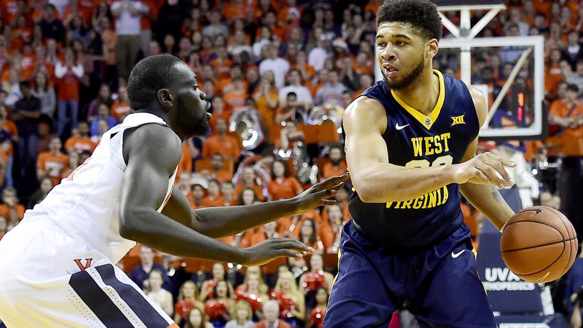 West Virginia forward Esa Ahmad brings the ball up court against the pressure of Virginia guard Marial Shayok during the first half Saturday.