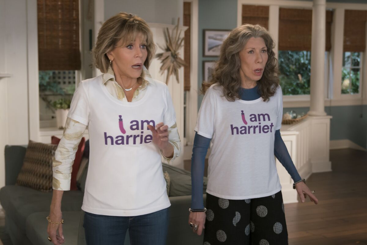 Jane Fonda and Lily Tomlin stand side by side in T-shirts that say "I am Harriet."