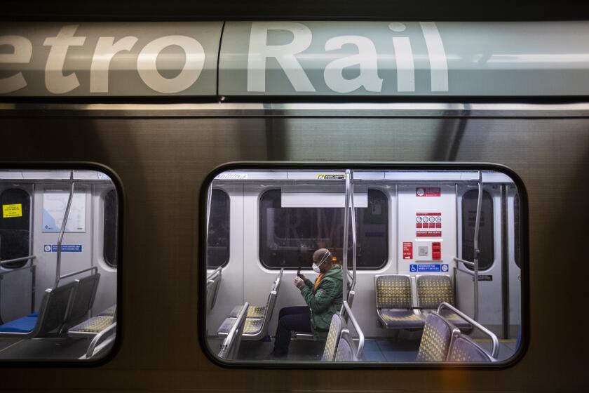 LOS ANGELES, CALIF. -- THURSDAY, MARCH 26, 2020: A man sits in a nearly empty train car on the Metro Blue Line at 7th St/Metro Center station in Los Angeles, Calif., on March 26, 2020. The coronavirus pandemic is causing ridership on LA Metro trains and busses to plummet. (Brian van der Brug / Los Angeles Times)