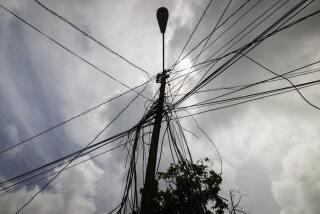 FILE - A utility pole with loose cables towers over a home in Loiza, Puerto Rico, Sept. 15, 2022. Towns in central and southern Puerto Rico are struggling to emerge from a prolonged power outage that forced authorities in the U.S. territory to activate an emergency response team on Monday, June 10, 2024, as they requested food distribution to those in need. (AP Photo/Alejandro Granadillo, File)