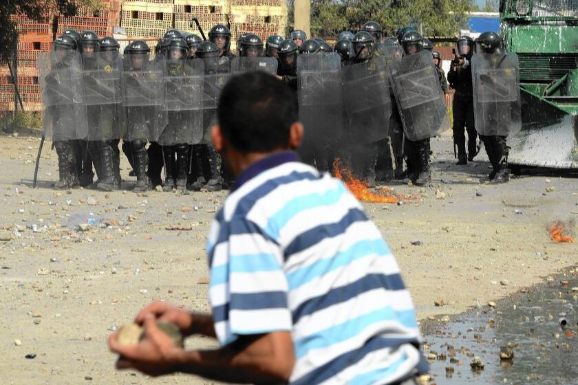 An Algerian man clashes with security forces in Raffour, southeast of Algiers, the capital, during a protest against the presidential elections on April 17, 2014.