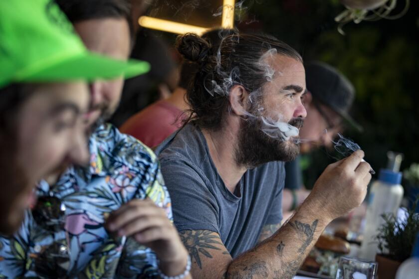 WEST HOLLYWOOD, CALIF. -- TUESDAY, OCTOBER 1, 2019: Patrons smoke cannabis at the Lowell Cafe a new restaurant and cannabis bar in West Hollywood allows diners to smoke marijuana inside and out thanks to a new license issued by the city in West Hollywood, Calif., on Oct. 1, 2019. (Brian van der Brug / Los Angeles Times)
