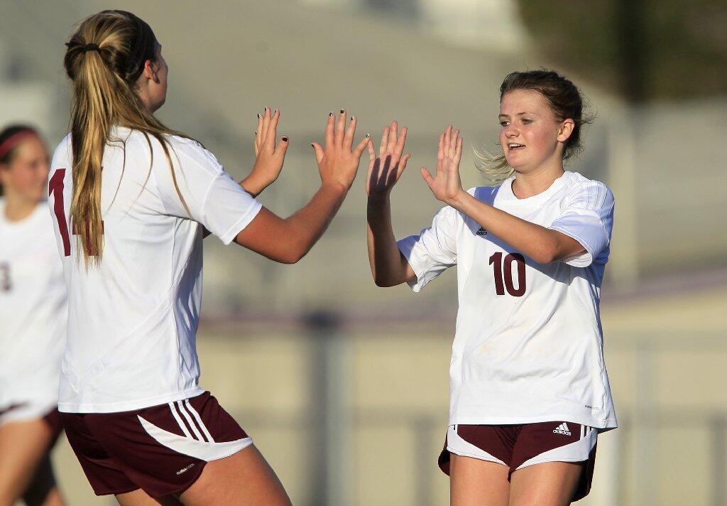 Laguna Beach High's Summer Stanaland, left, congratulates teammate Regan Caraher (10) on a goal scored against Chaffey in a CIF Southern Section Division 4 first-round playoff game at Guyer Field on Friday.