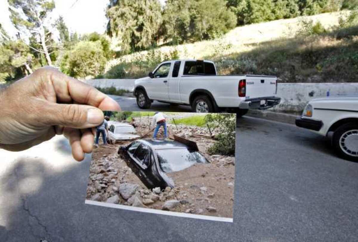 Local resident Gilbert Jacobi, who is happy to have K-rails in front of his home in the 5400 block of La Forest Drive, shows photos of his cars that were covered by mudflows during the 2010 storms.