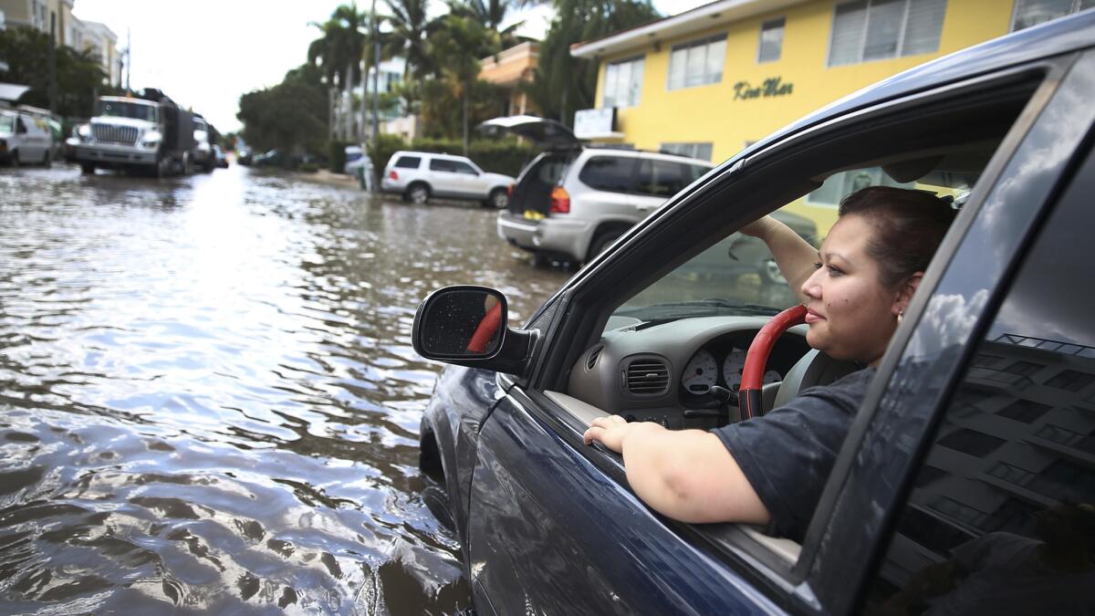 Sandy Garcia sits in her vehicle on a flooded street in Fort Lauderdale, Florida, in 2015.