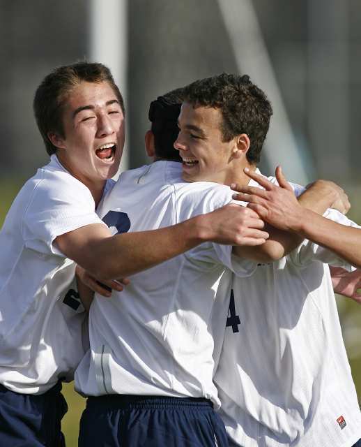 Corona del Mar's Connor Morrill, left, and Grady Howe, right, celebrate with Jack Gorab after he scored on a penalty against Santa Ana Valley in a CIF Southern Section Division III second-round playoff game.