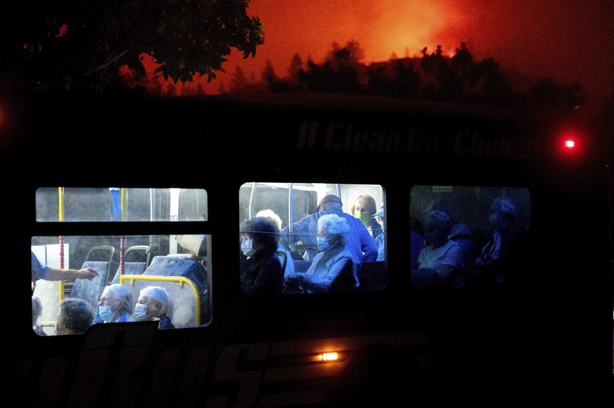 Residents of the Oakmont Gardens senior home evacuate on a bus as the Glass fire approaches Santa Rosa on Monday.