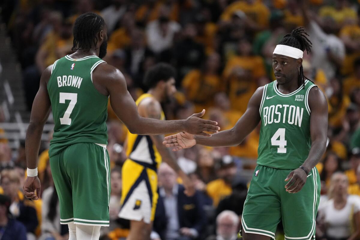 Boston's Jaylen Brown, left, and Jrue Holiday slap hands during the second half.