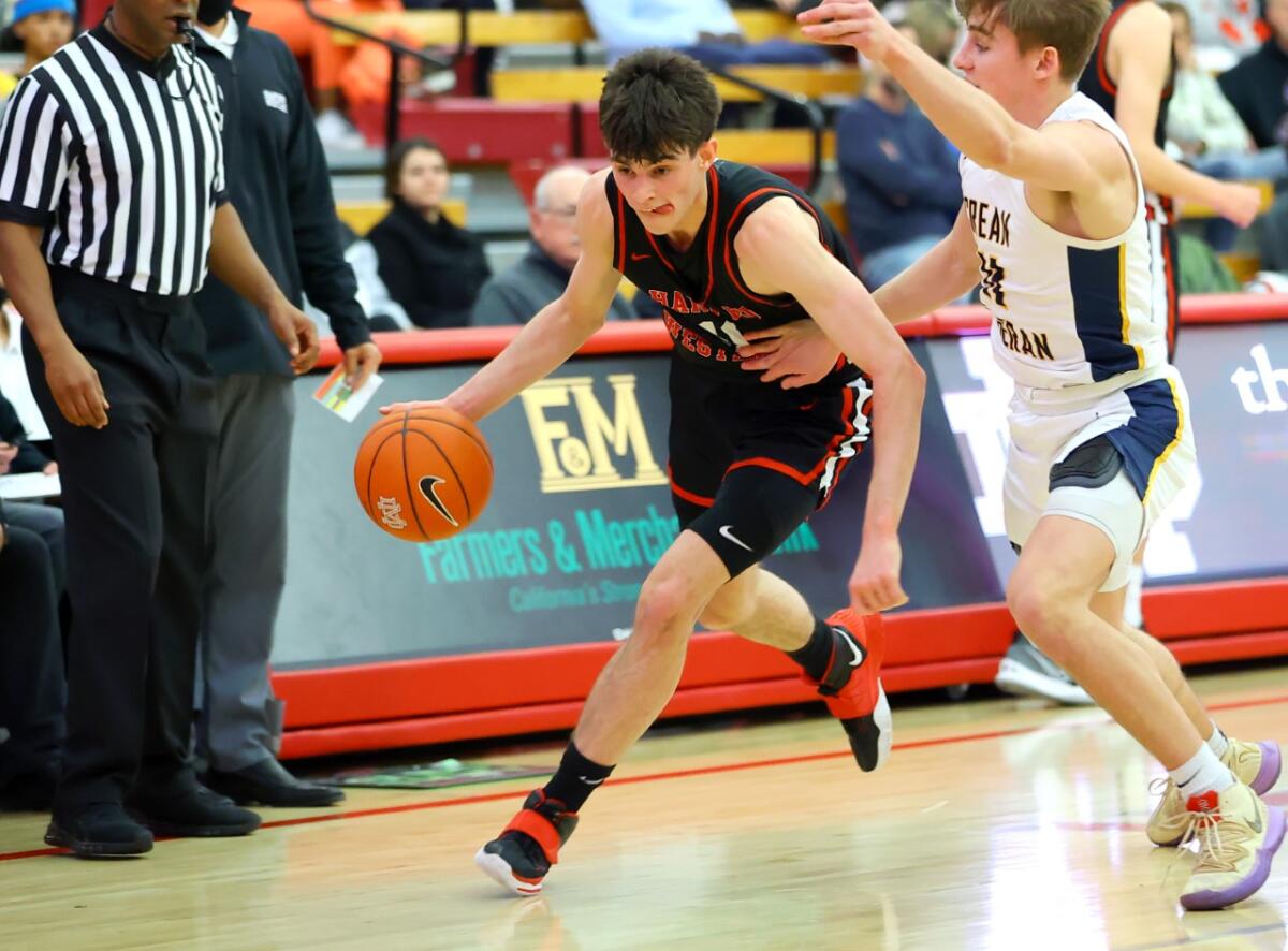 Brady Dunlap of Harvard-Westlake dribbles upcourt against a defender