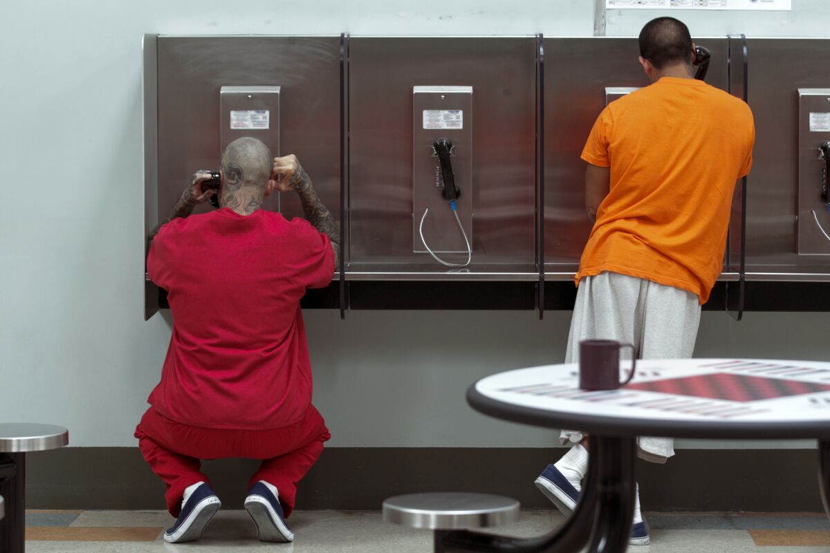 Detainees make phone calls from their housing area at Adelanto Detention Facility.