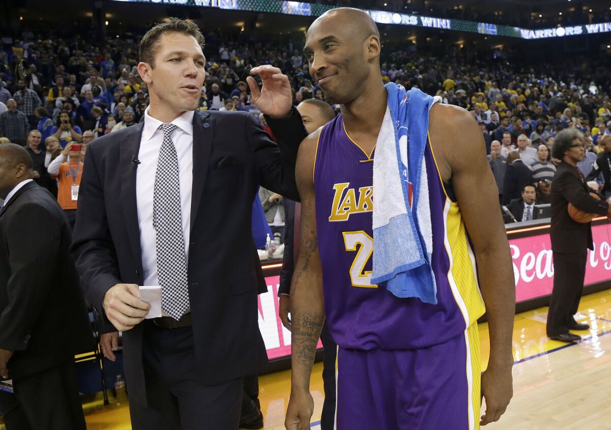 Golden State interim Coach Luke Walton walks off the court with Kobe Bryant after the Warriors' 111-77 victory over the Lakers on Nov. 24.
