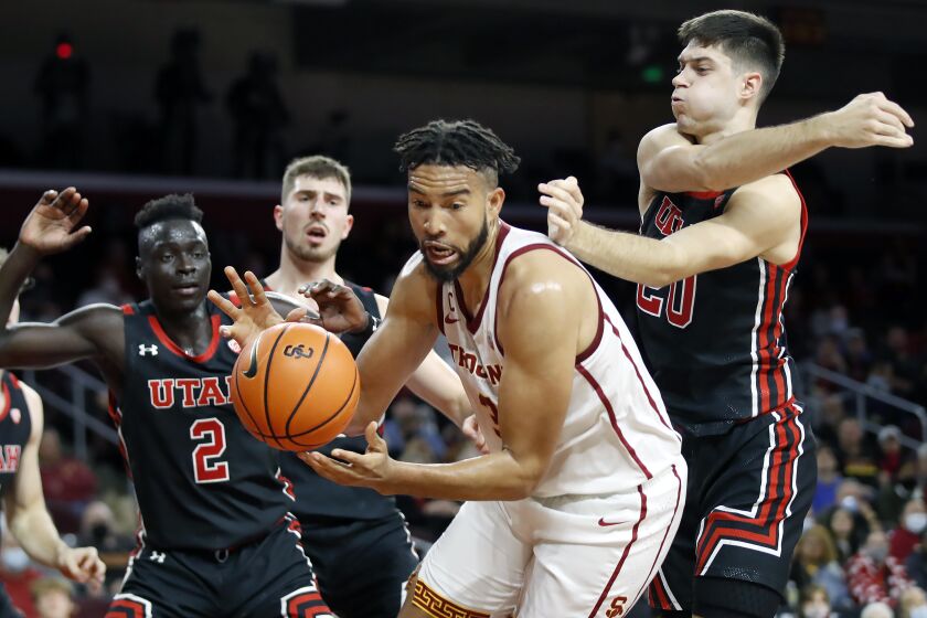 Southern California forward Isaiah Mobley, second from right, pulls down a rebound against Utah guard Both Gach (2) and guard Lazar Stefanovic (20) during the second half of an NCAA college basketball game in Los Angeles, Wednesday, Dec. 1, 2021. (AP Photo/Alex Gallardo)
