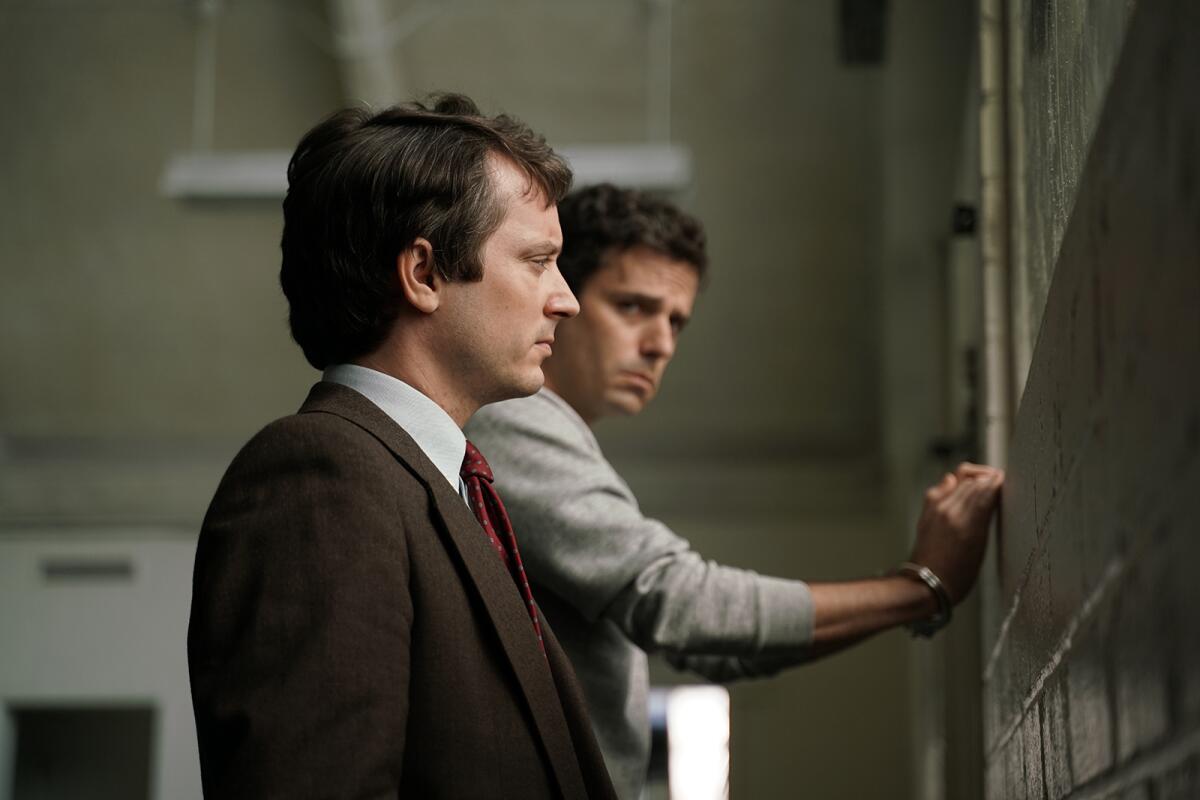 Two men face a wall in "No Man of God."