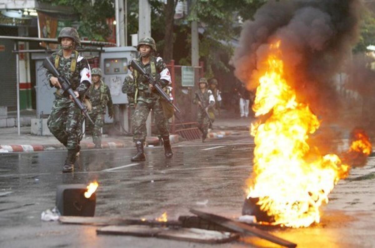 Thai troops advance in Bangkok where pro-Thaksin protesters blocked roads and lobbed tear gas and firebombs at the military, which returned fire with live ammunition. Prime Minister Abhisit appeared on TV with army brass to dispel rumors of a coup. Former Prime Minister Thaksin gave a video message to rally the protesters, even urging soldiers to join in. Related story: Thailand violence claims two lives