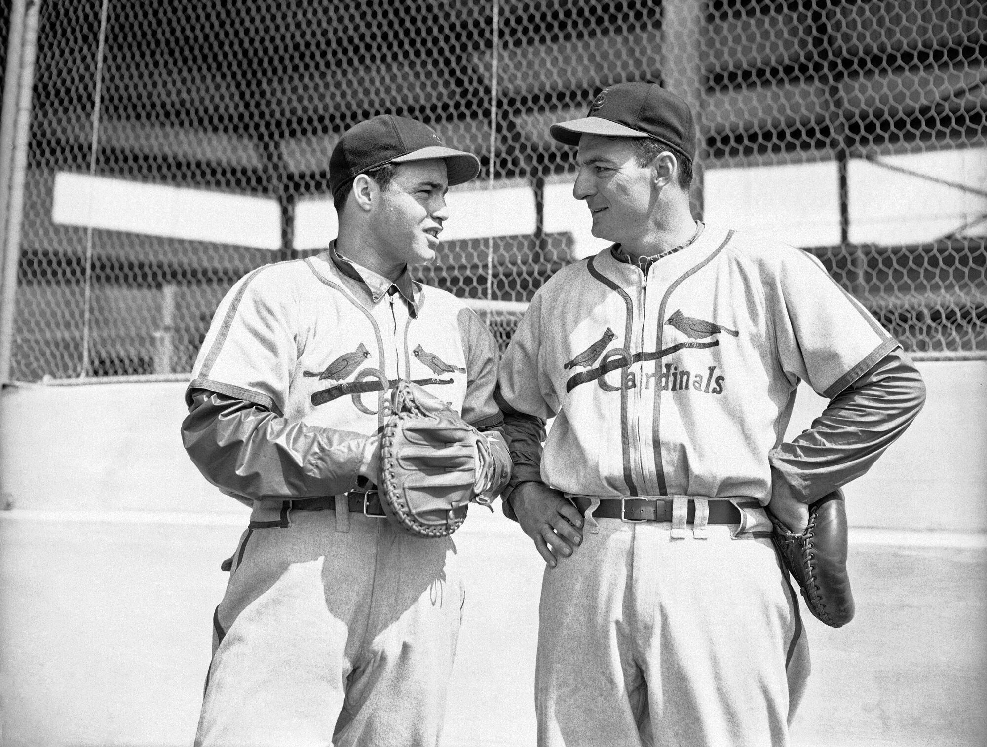Catchers Joe Garagiola, left, and Del Wilber of the St. Louis Cardinals, chat during morning workout of the team in 1947.
