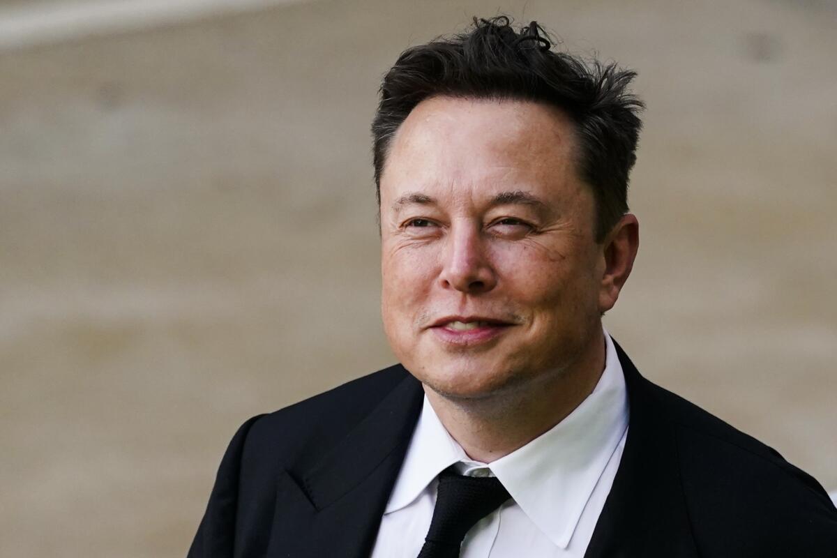 Elon Musk is dressed in a suit and tie.