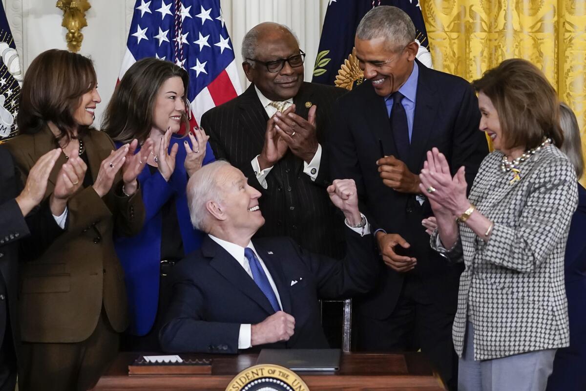 President Biden surrounded by President Obama, Vice President Kamala Harris, House Speaker Nancy Pelosi and others.