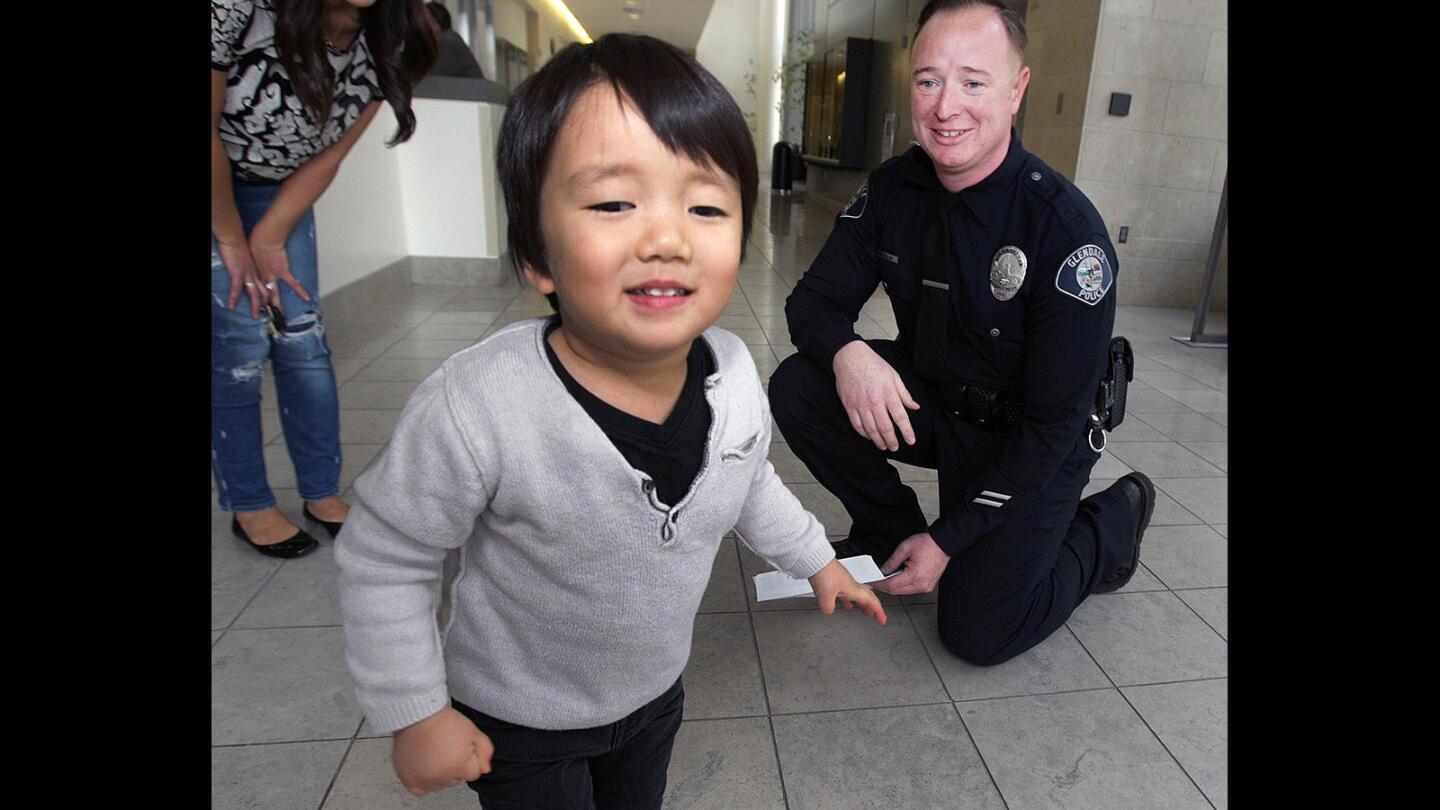 Clayton Cha, 3, runs for the door after giving Glendale Police Officer James Colvin a hug at the Glendale Police Department on Thursday, January 22, 2016. Colvin, in April, 2015, was the first on the scene to treat then 2-year-old Clayton Cha who had fallen on his head from 22-feet onto concrete. Today was the first day Colvin has seen the now 3-year-old boy who is doing miraculously well.