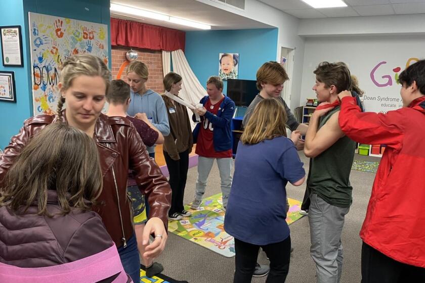 Gigi's Playhouse youth board members and participants utilizing teamwork to "wrap mummies" during a recent holiday program.
