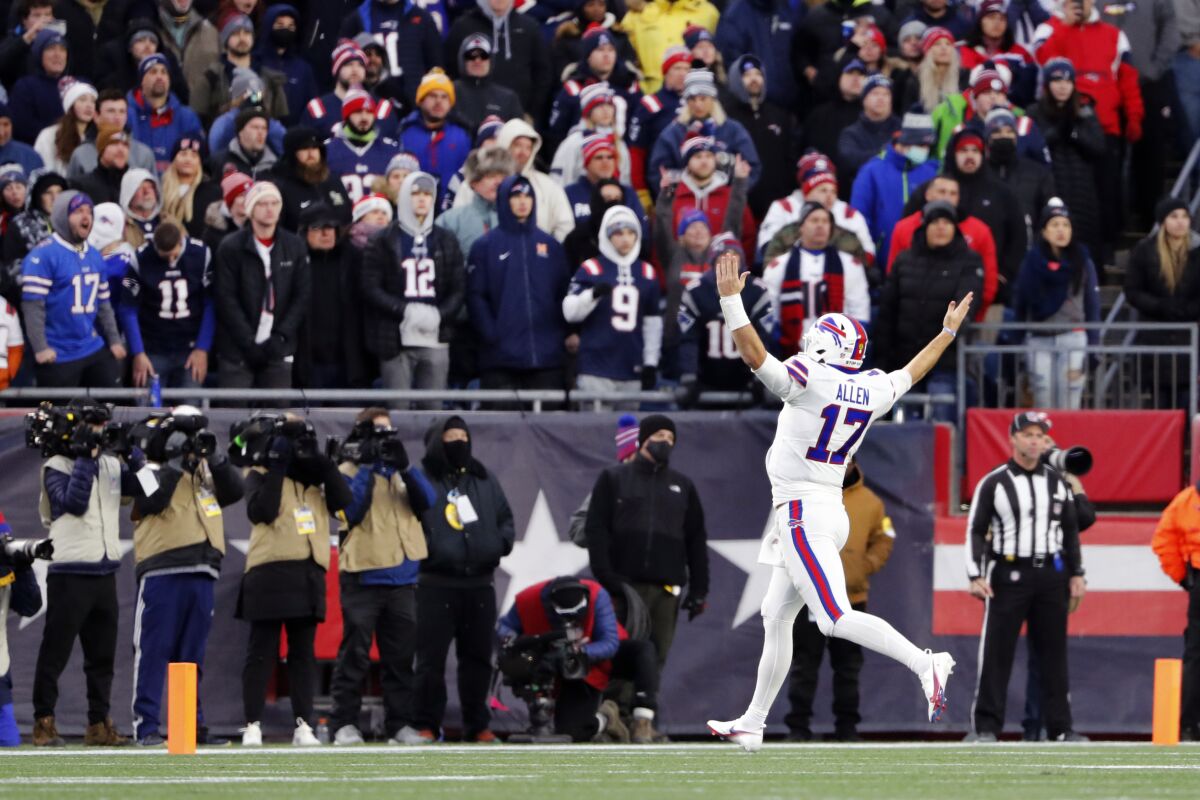 FILE - Buffalo Bills quarterback Josh Allen (17) celebrates in front of fans in Foxborough, Mass., after a touchdown by tight end Dawson Knox during the second half of an NFL football game, Sunday, Dec. 26, 2021. The Bills beat the Patriots 33-21. Bill Belichick and the New England Patriots dominated the Buffalo Bills from 2000 to 2019, it was difficult to dub it a rivalry. The tables finally seem to be turning in the AFC East, with Buffalo having won three of four and consecutive division titles, in preparing to host New England in a wild-card playoff on Saturday night. (AP Photo/Winslow Townson, File)
