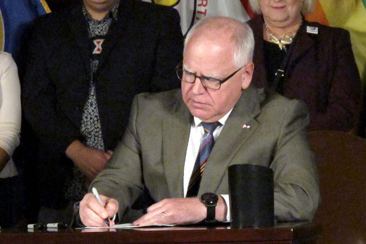 Minnesota Gov. Tim Walz signing an executive order