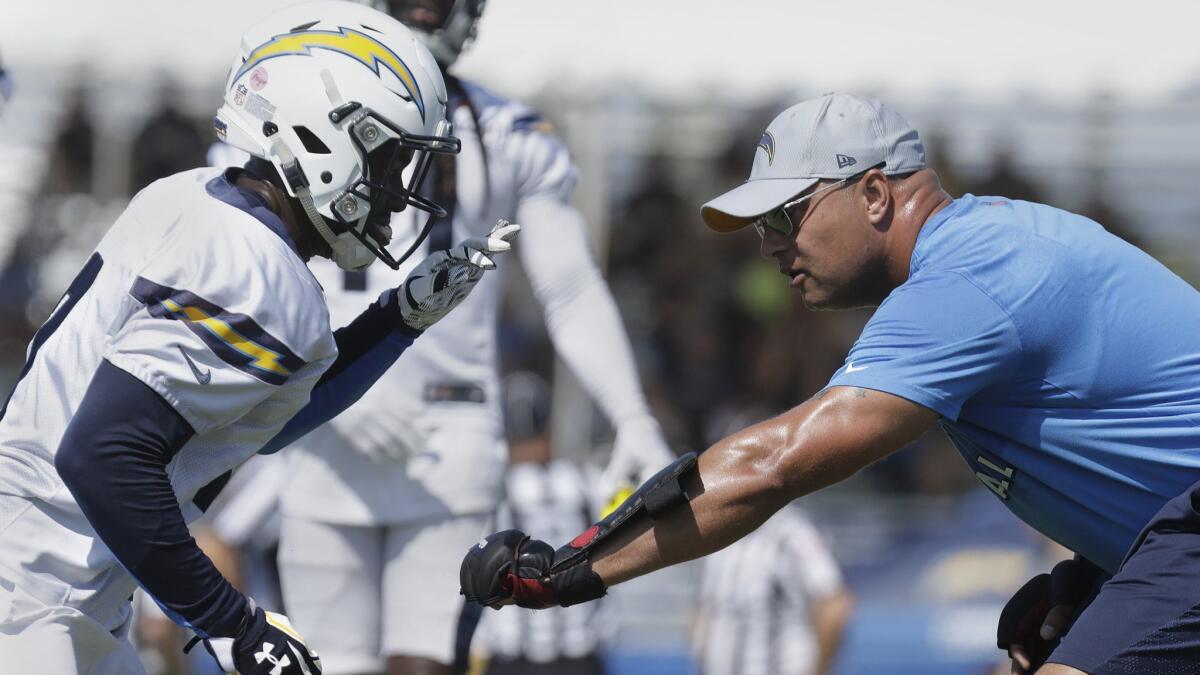 Los Angeles Chargers wide receivers coach Phil McGeoghan wears combat training gloves while working with wide receivers during training camp at Jack R. Hammett Sports Complex in Costa Mesa.