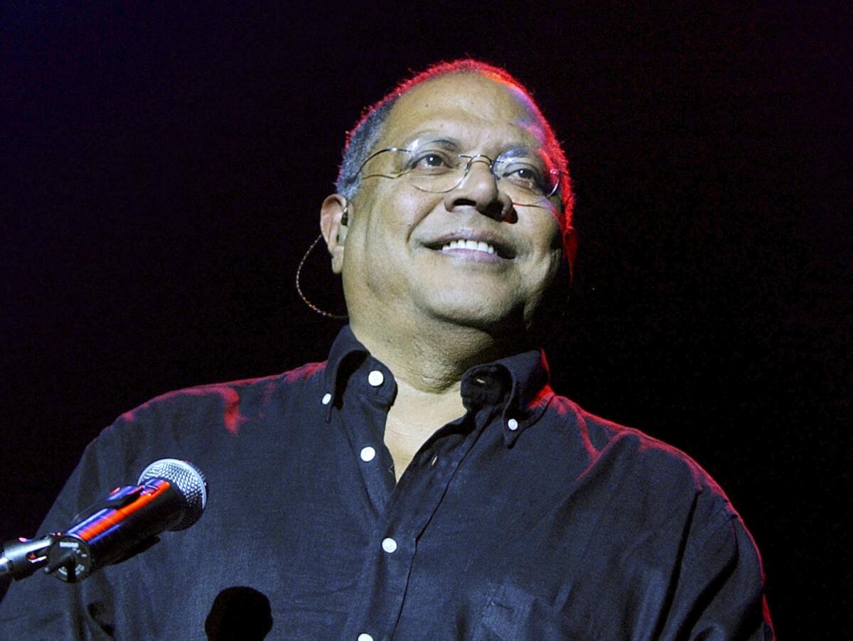 Pablo Milanés smiles at a microphone.