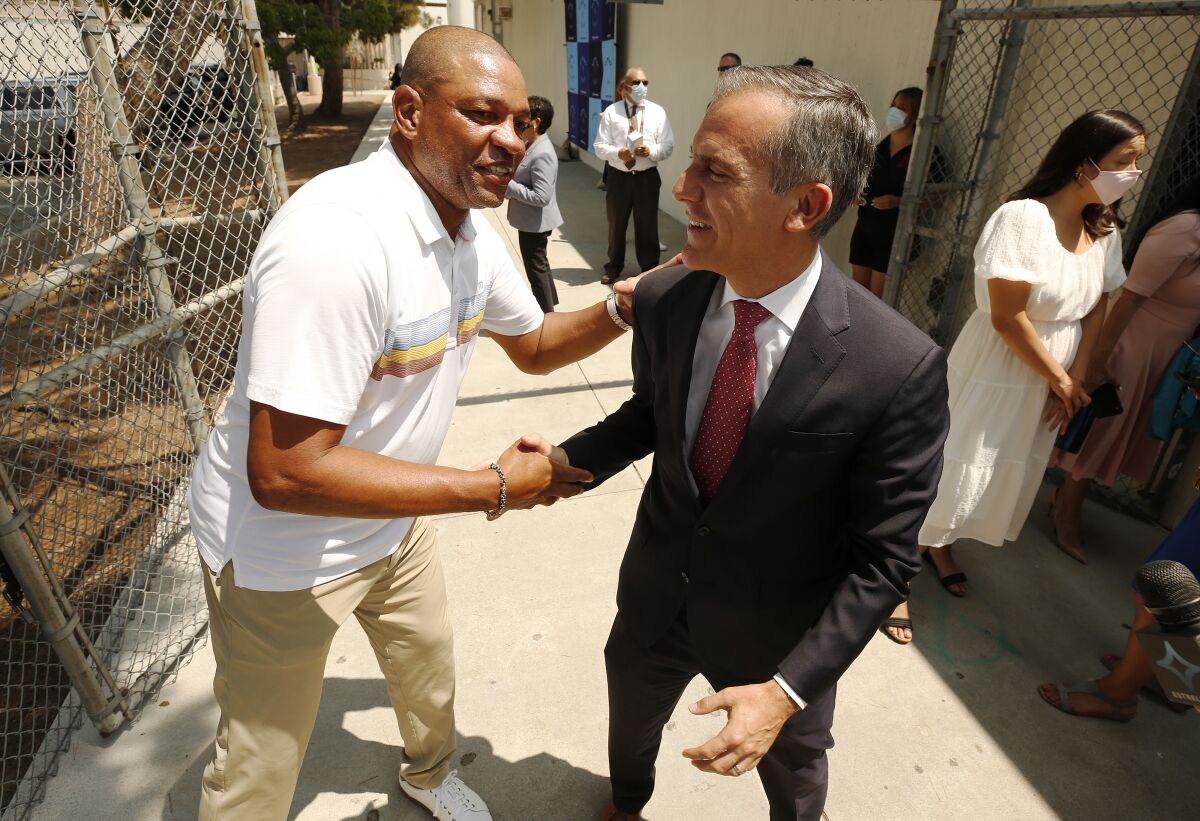 Doc Rivers shakes hands with Mayor Eric Garcetti during an event at Fairfax High to launch a program to recruit mentors.