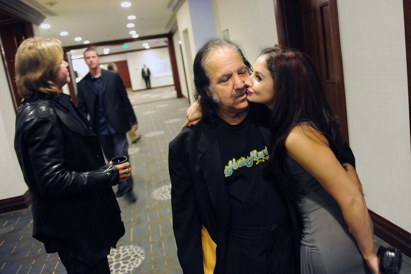 Veteran performer Ron Jeremy is greeted by Shena Ryder at the XBiz adult awards.