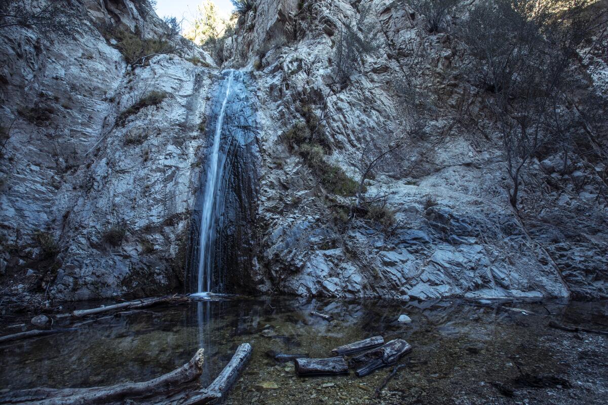 A thin waterfall pours into a small pool.