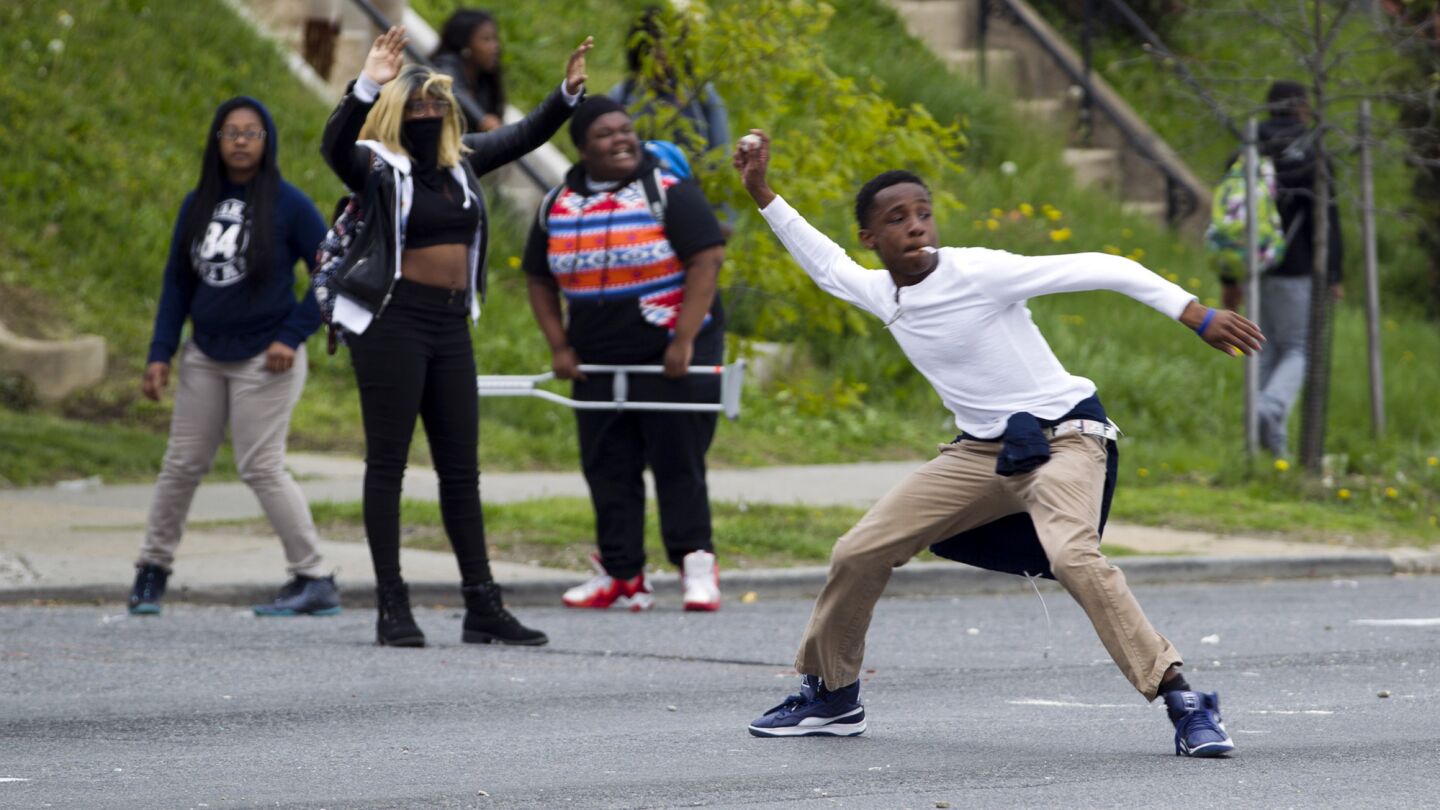 Demonstrators throw rocks at police after the funeral of Freddie Gray.