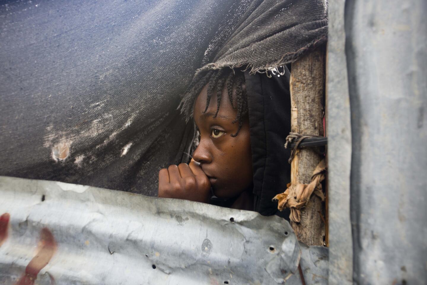 A girl watches as the authorities arrive to evacuate people from her house in Tabarre, Haiti, on Oct. 3, 2016.