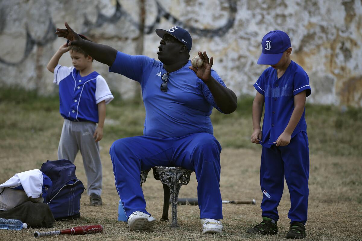 Lazaro Castillo, a retired baseball player who played for the 12-time Cuban League champion Industriales, coaches 7- and 8-year-olds in an instructional little league. (Robert Gauthier / Los Angeles Times)