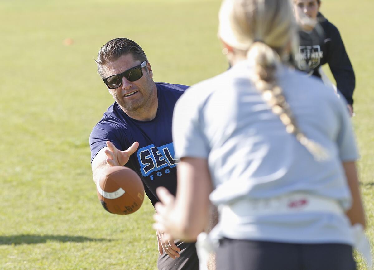 Coach Jason Guyser hikes the ball during the Seals Football Club practice on Wednesday.