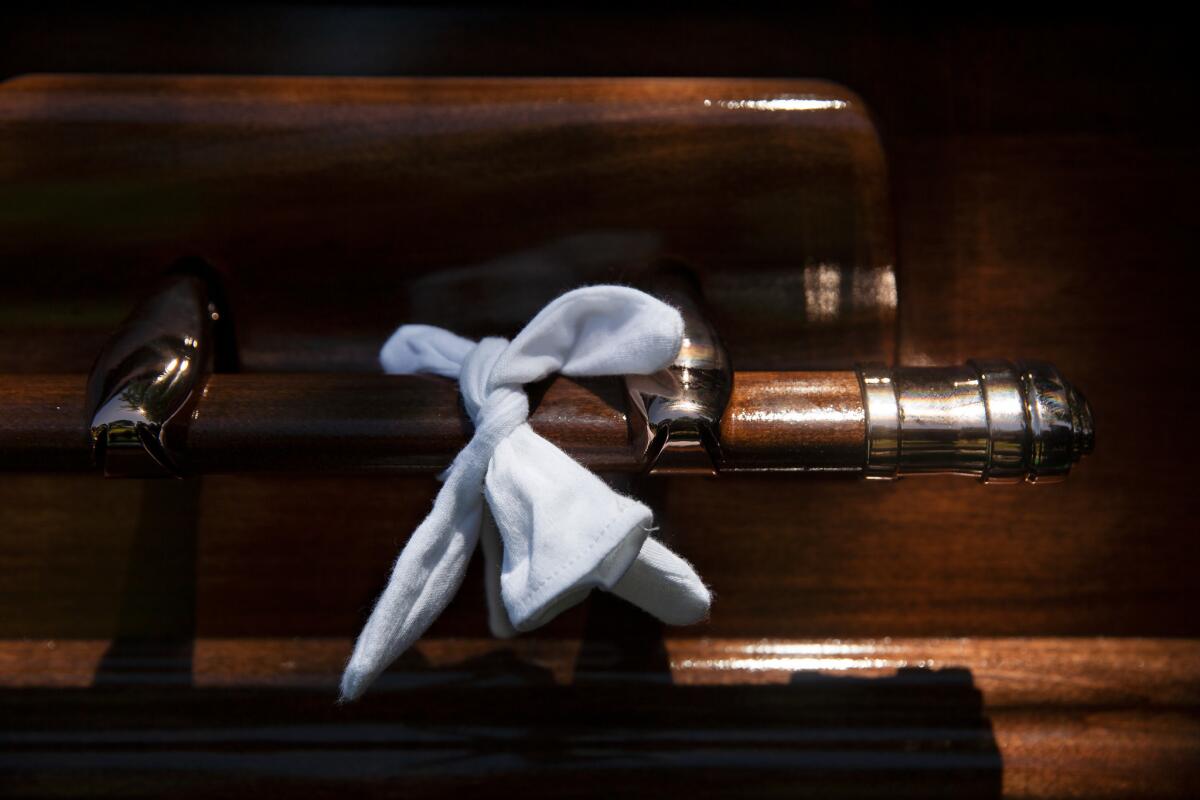 Ruben Valencia's white glove used to carry Raul Guerra's casket is tied to the handle as a reminder that "No man is left behind." (Dania Maxwell / Los Angeles Times)