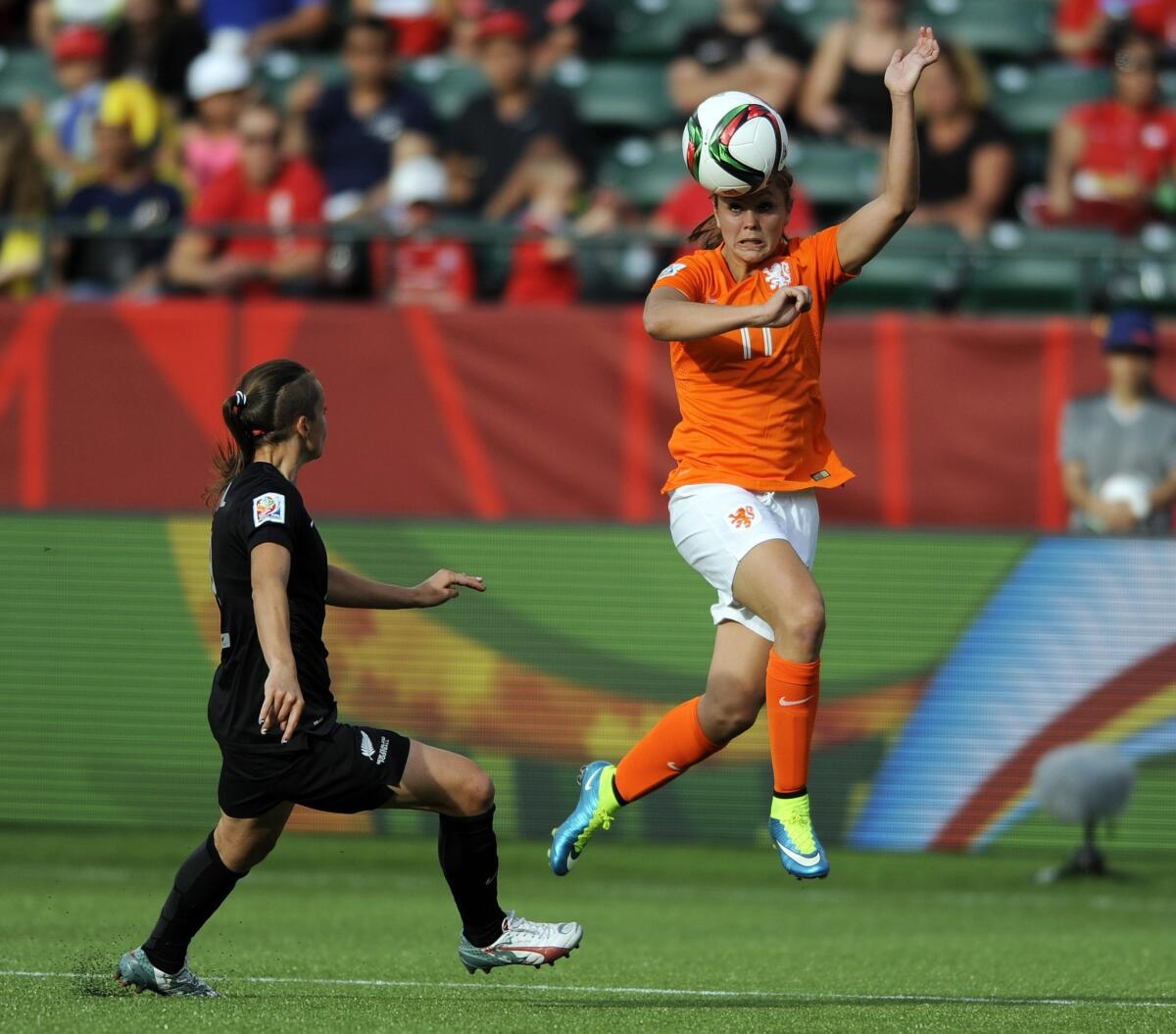 Netherlands' Lieke Martens heads the ball near New Zealand's Ria Percival during a 2015 Women's World Cup match.
