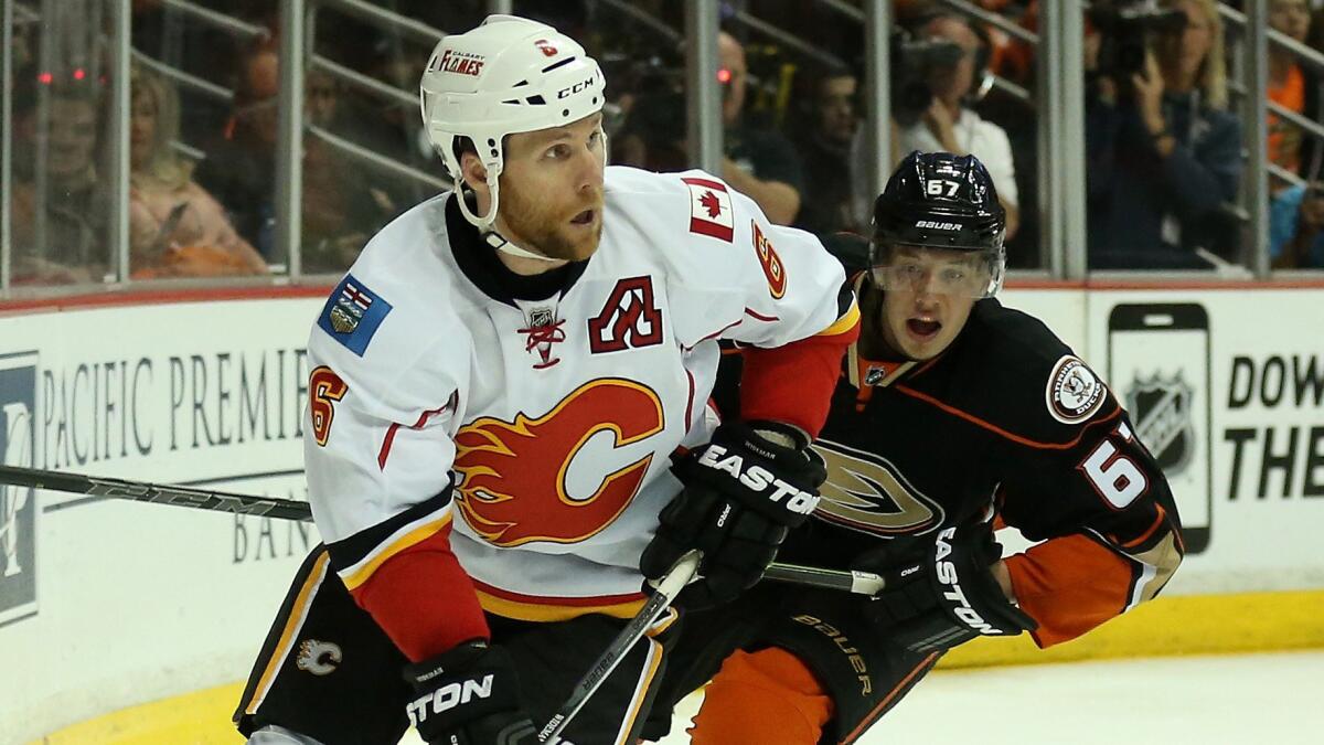 Calgary Flames defenseman Dennis Wideman controls the puck ahead of Ducks forward Rickard Rakell during Game 1 of the Western Conference semifinals in Anaheim on April 30.
