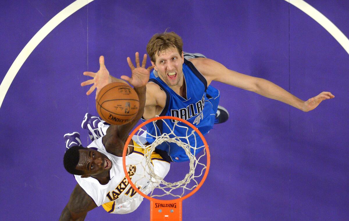 Lakers forward Brandon Bass and Dallas Mavericks forward Dirk Nowitzki battle for a rebound during the first half of a game on Nov. 1. The Lakers lost that game, 93-103.