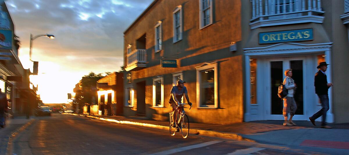 Late afternoon sunbeams on San Francisco Street highlight the texture of downtown Santa Fe's adobe-inspired architecture.