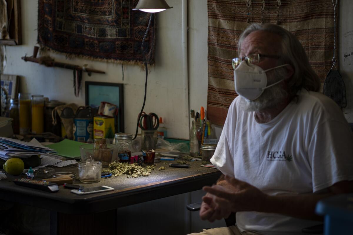 Kendall Steinmetz of Anza, Calif., at his living room table, where he trims his cannabis buds