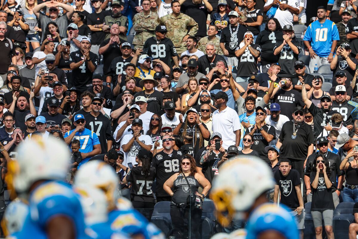 Chargers players line up near the goal line as a multitude of Raiders fans show their support of their team.